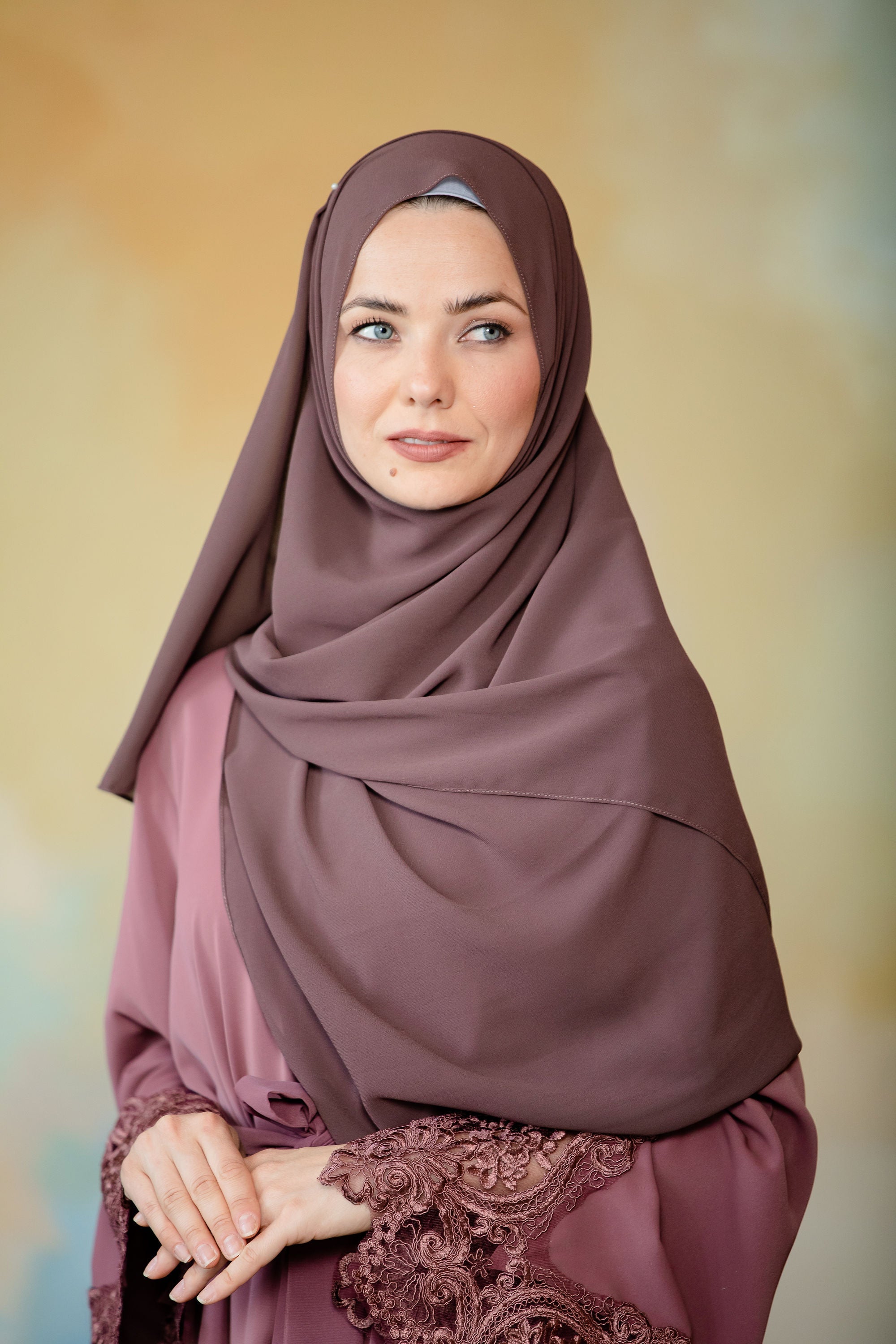 Woman in hijab and embroidered robe in dark brown chiffon