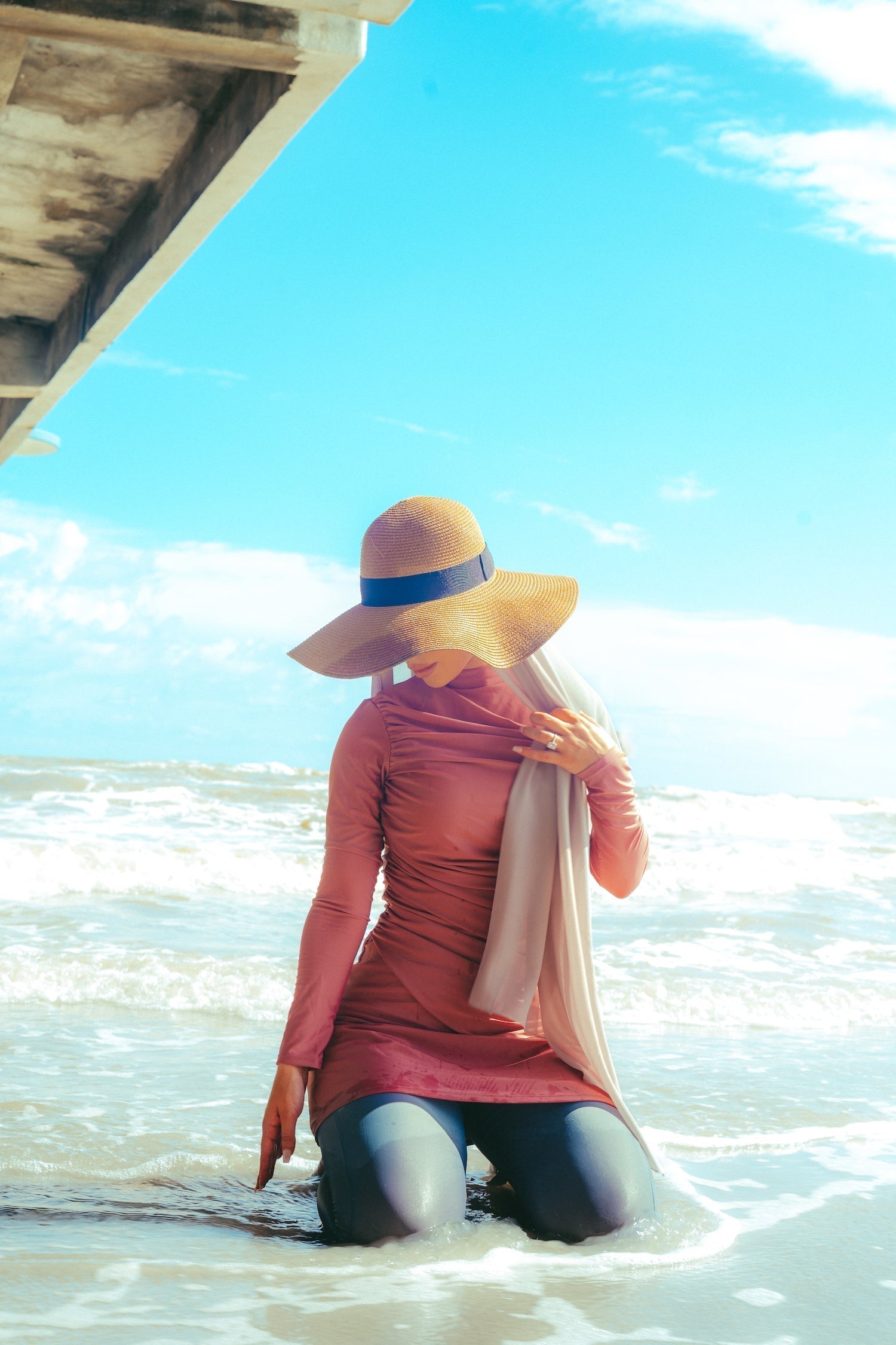 Woman in ruched 3-piece modest swimsuit and sun hat